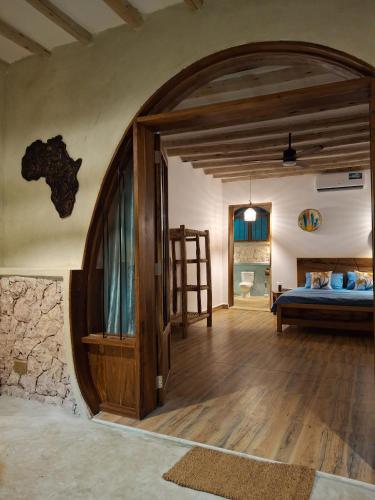 a bedroom with a bed and a large doorway at Hakuna Marika in Umbuji
