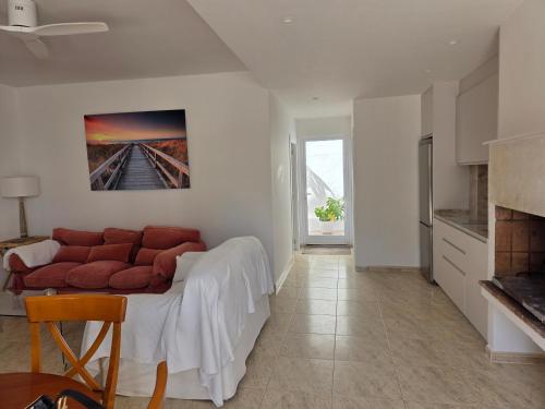 a living room with a couch and a painting on the wall at Planta baja junto al mar con barbacoa in El Brosquil