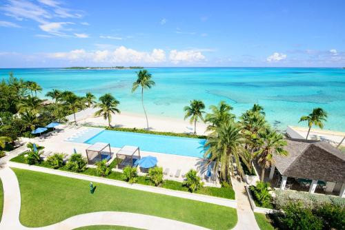 an aerial view of a resort with a swimming pool and the ocean at Garden Villa Condo at ONE Cable Beach in Nassau