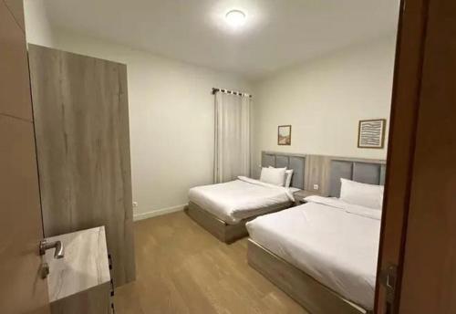a hotel room with two beds and a window at parkoo jajaaa in Dammam