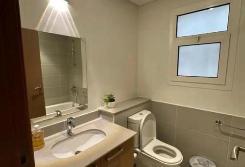 a bathroom with a sink and a toilet and a window at parkoo jajaaa in Dammam