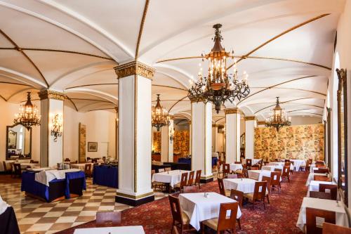 a dining room with tables and chairs and chandeliers at Arlington Resort Hotel & Spa in Hot Springs