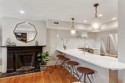 a kitchen with a fireplace and a counter with stools at Cozy Charming Historic Home in Savannah