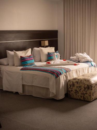 a bedroom with a large bed with white sheets and pillows at Ohasis Hotel Jujuy & Spa in San Salvador de Jujuy