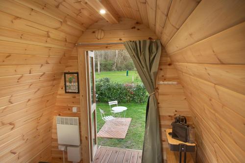 an inside view of a wooden cabin with a patio at Pod View-side river am clerve in Enscherange
