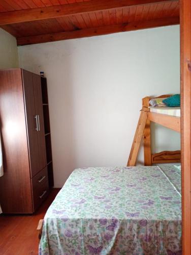 a bedroom with a bed and a bunk bed at La esquina amarilla in San Clemente del Tuyú