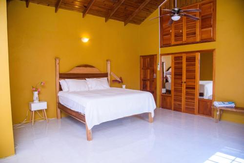 a bedroom with a bed and a yellow wall at Destiny Seaside in Content