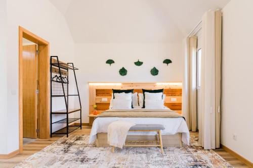 a bedroom with a large bed and a chair at Casa Ti'Vina in Caniço