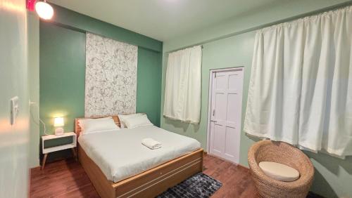 a small bedroom with a bed and a chair at Celeste Inn in Shillong