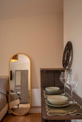 a room with a mirror and a table with plates and glasses at Paradise Retreat in Cambridge