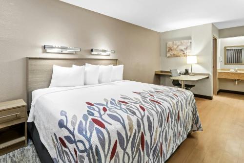 a hotel room with a bed and a desk at Red Roof Inn Dayton North Airport in Dayton