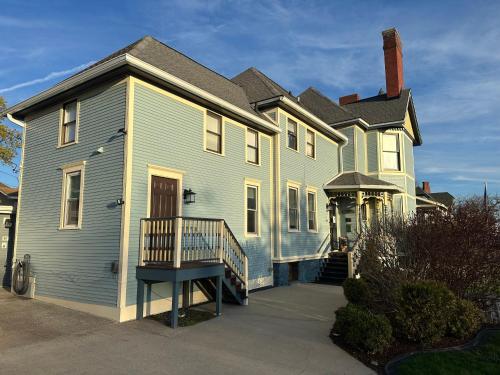 a large blue house with a porch in front of it at The Fresh Coast Inn at Ludington in Ludington