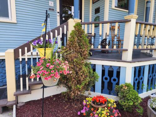 a house with a porch with flowers on it at The Fresh Coast Inn at Ludington in Ludington