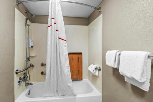 a bathroom with a tub and a shower with towels at Red Roof Inn Dayton North Airport in Dayton