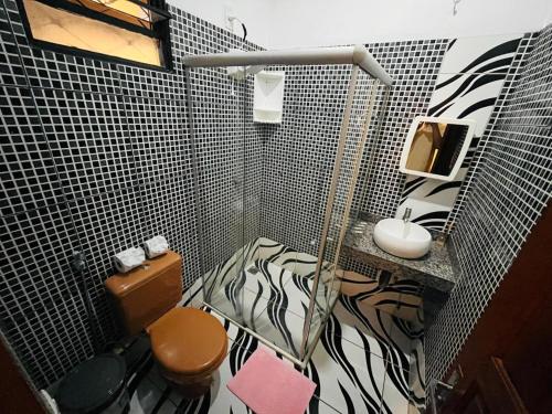 a bathroom with a black and white tiled wall at Pousada da Praça in Ponte Alta do Tocantins