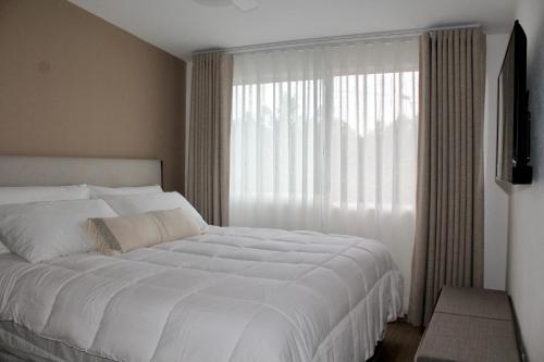 a bedroom with a large white bed and a window at Single Suite Unbeatable Location Internet b34 in Casa Blanca La Corregidora