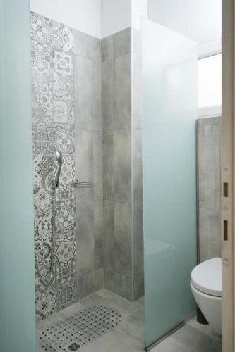 a bathroom with a shower and a toilet at Thalassoresort UPSTAIRS in Matala