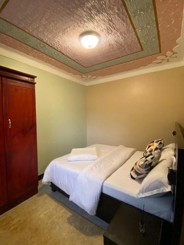 a bedroom with a large bed with a ceiling at Flat in Jinja City in Jinja