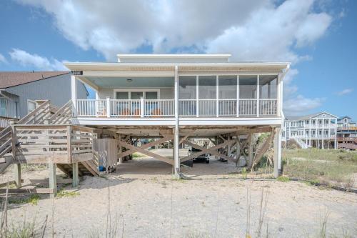a house on the beach with a large deck at 7th Heaven by Oak Island Accommodations in Oak Island