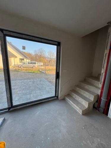 a room with a sliding glass door and stairs at Perła pod Śnieżką in Miłków