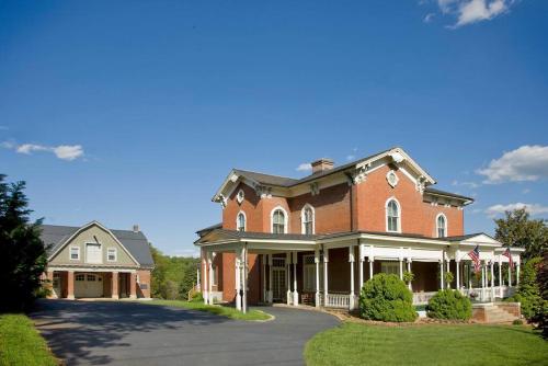 a large red brick house with a driveway at One of These Nights - King Sized Bed - Sleeps 2 in Lynchburg