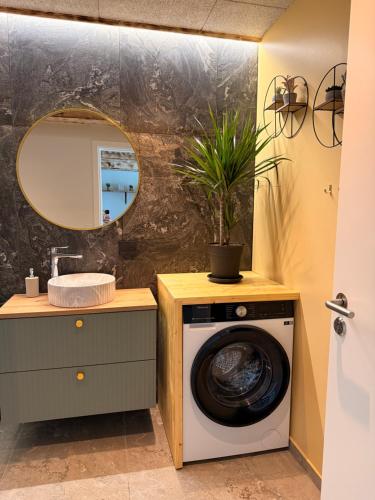 a bathroom with a washing machine and a mirror at Hygge Green Retreat Billund 102 in Give