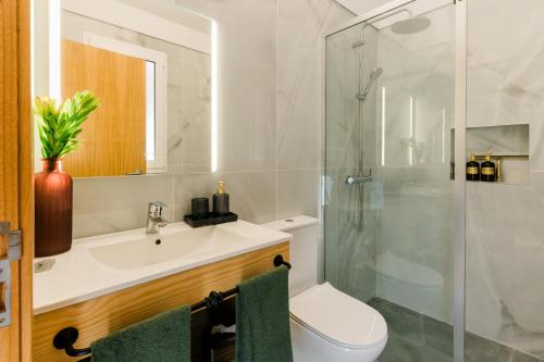 a bathroom with a toilet and a sink and a shower at Casa Ti'Vina in Caniço