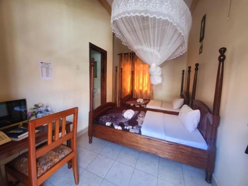 a bedroom with a large wooden bed with a chandelier at Uhuru 50 Hotel in Kasese