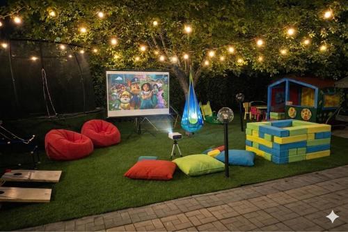 a play area with colorful chairs and lights and a screen at Casa Asteria - Mamaia Nord in Mamaia Sat/Năvodari