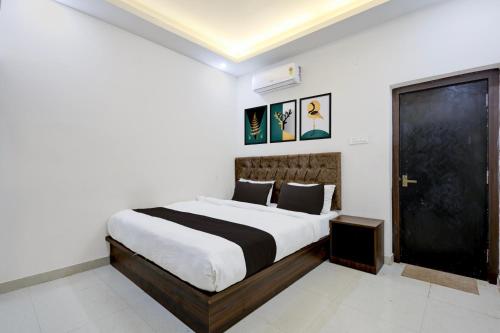 a bedroom with a large bed with a black door at Hotel O White House in Rānchī