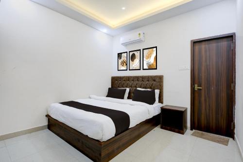 a bedroom with a large bed and a wooden door at Hotel O White House in Rānchī