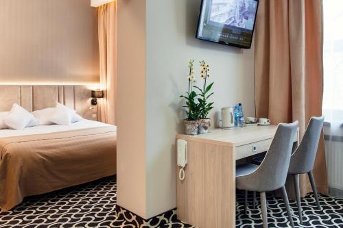 Habitación de hotel con cama y escritorio con 2 sillas en Art Hotel's Sosnowiec en Sosnowiec