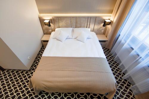 a bedroom with a large bed with white sheets and pillows at Art Hotel's Sosnowiec in Sosnowiec