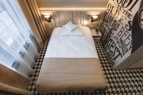 a bed in a small room with a window at Art Hotel's Sosnowiec in Sosnowiec
