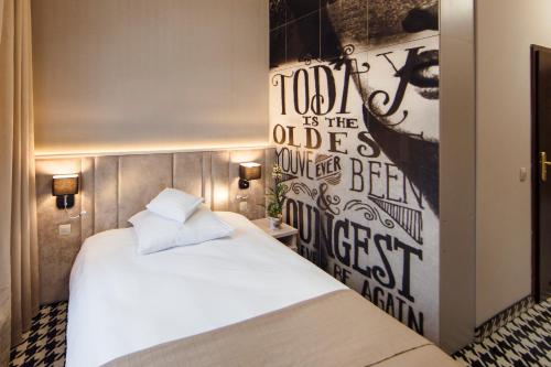 a bedroom with a bed and a poster on the wall at Art Hotel's Sosnowiec in Sosnowiec