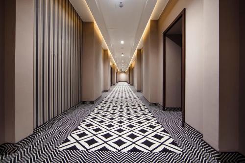 a hallway with black and white flooring in a building at Art Hotel's Sosnowiec in Sosnowiec