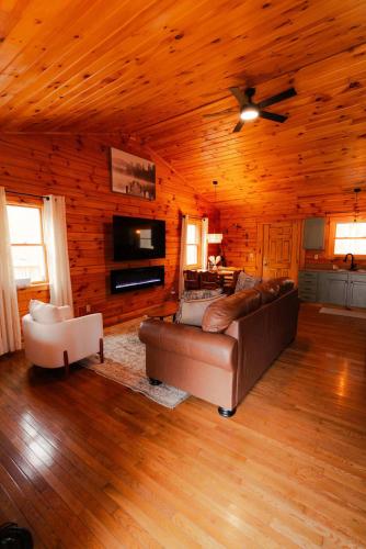 a living room with a couch and a ceiling fan at Secluded Cozy Log Cabin Villa in Creola