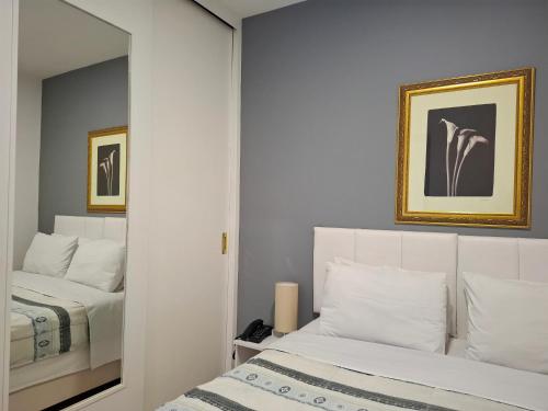 a bedroom with two beds and a mirror at Flat INCRIVEL na Vila Olimpia in São Paulo