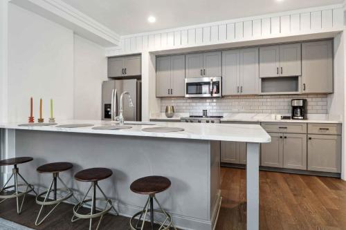 a kitchen with a large island with bar stools at Contemporary Condo Downtown Savannah in Savannah