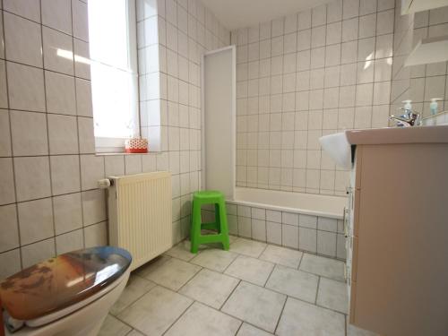 a bathroom with a toilet and a green stool at Ferienwohnung in Elbingerode by Belvilla in Elbingerode