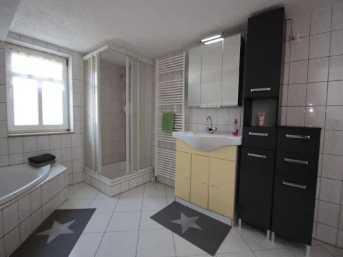 a bathroom with a sink and a bath tub and a sink at behagliche Ferienwohnung in Elbingerode in Elbingerode