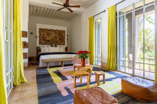 a bedroom with a bed and a room with yellow curtains at Villa ouidane in Marrakesh