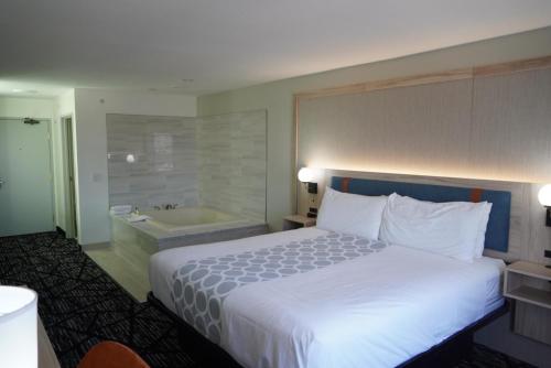 a hotel room with a bed and a bath tub at Bay Inn & Suites Troy in Troy