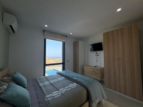 a bedroom with a bed and a large window at Vivienda en Granada, Cortijo Balcón Cotobro, Almuñécar, Casa con piscina y vistas increíbles in Granada