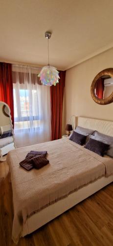 a bedroom with a large bed and a mirror at Apartament La Torre in Torrevieja
