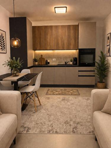 a living room with a table and a kitchen at Holiday apartaments Gaca in Lezhë