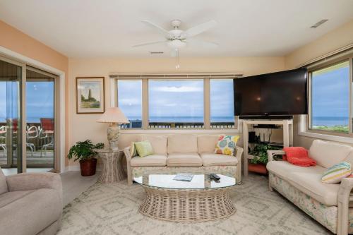 a living room with a couch and a table at A Searious Sunset View by Oak Island Accommodations in Caswell Beach
