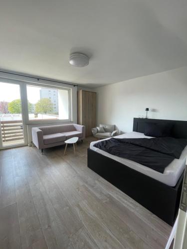 a bedroom with a large bed and a couch at Wohnen Nähe Salzgittersee in Salzgitter