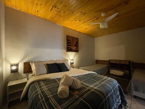 a bedroom with a bed with a wooden ceiling at Sentiero Lofts in Urubici