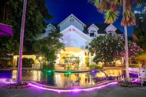 a building with a fountain in front of it at night at Pooh Beach Resort & Spa in Jomtien Beach